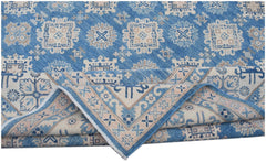 A handmade Afghan Kazakh rug featuring a blue field with beige geometric patterns and a folded edge.