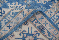 A handmade Afghan Kazakh rug featuring a geometric pattern in shades of blue, beige, and grey.