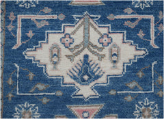 Handmade Afghan Kazakh runner featuring a central geometric floral motif on a blue wool background.