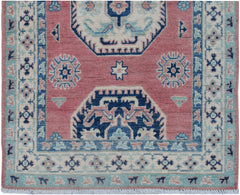 Handmade Afghan Kazakh runner rug featuring traditional geometric motifs in pink and blue.