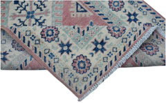 A handmade Afghan Kazakh runner featuring traditional geometric motifs in blue, pink, and cream.