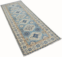 An Afghan Kazakh runner rug featuring a geometric pattern in shades of blue and beige.