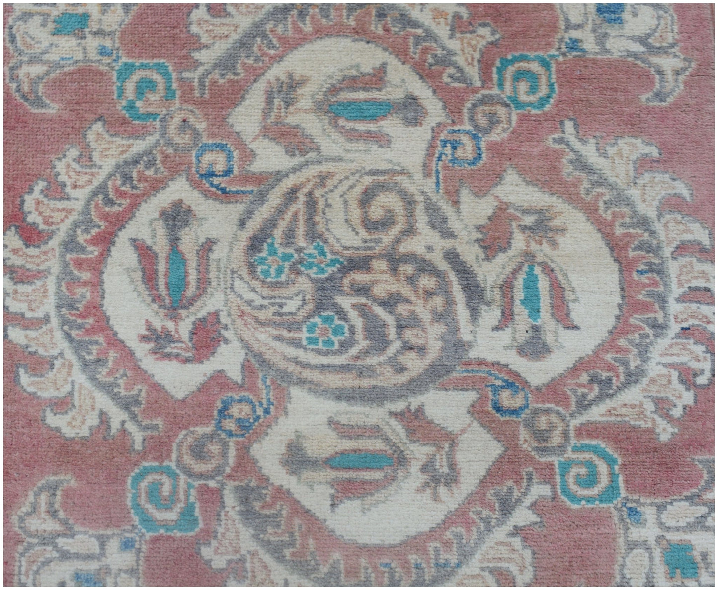 An Afghan Kazakh runner featuring a traditional floral medallion pattern in pink, blue, and cream.