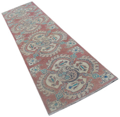 A handmade Afghan Kazakh runner rug featuring traditional motifs in pink, cream, and blue tones.