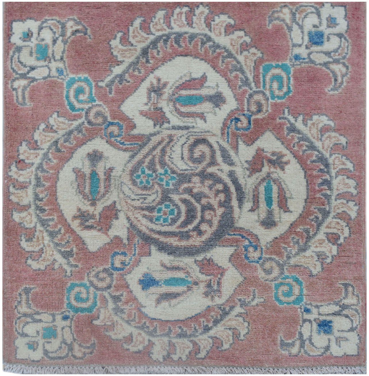 A handmade Afghan Kazakh runner featuring traditional floral motifs in pink, cream, and blue.