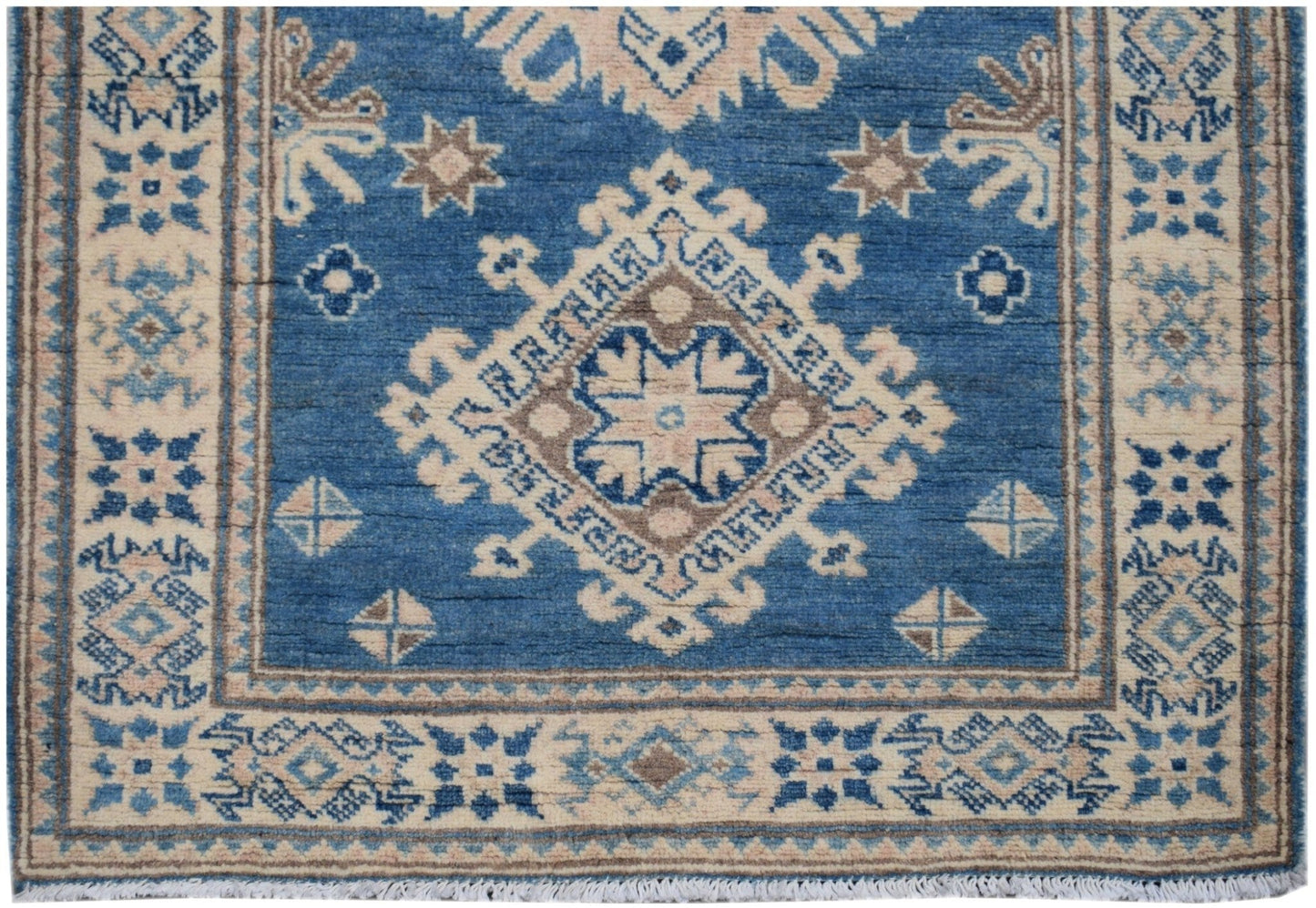 Handmade Afghan Kazakh runner rug featuring a blue field with beige and brown geometric patterns.