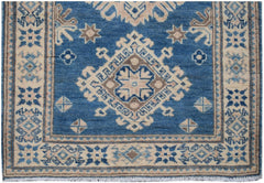 Handmade Afghan Kazakh runner rug featuring a blue field with beige and brown geometric patterns.