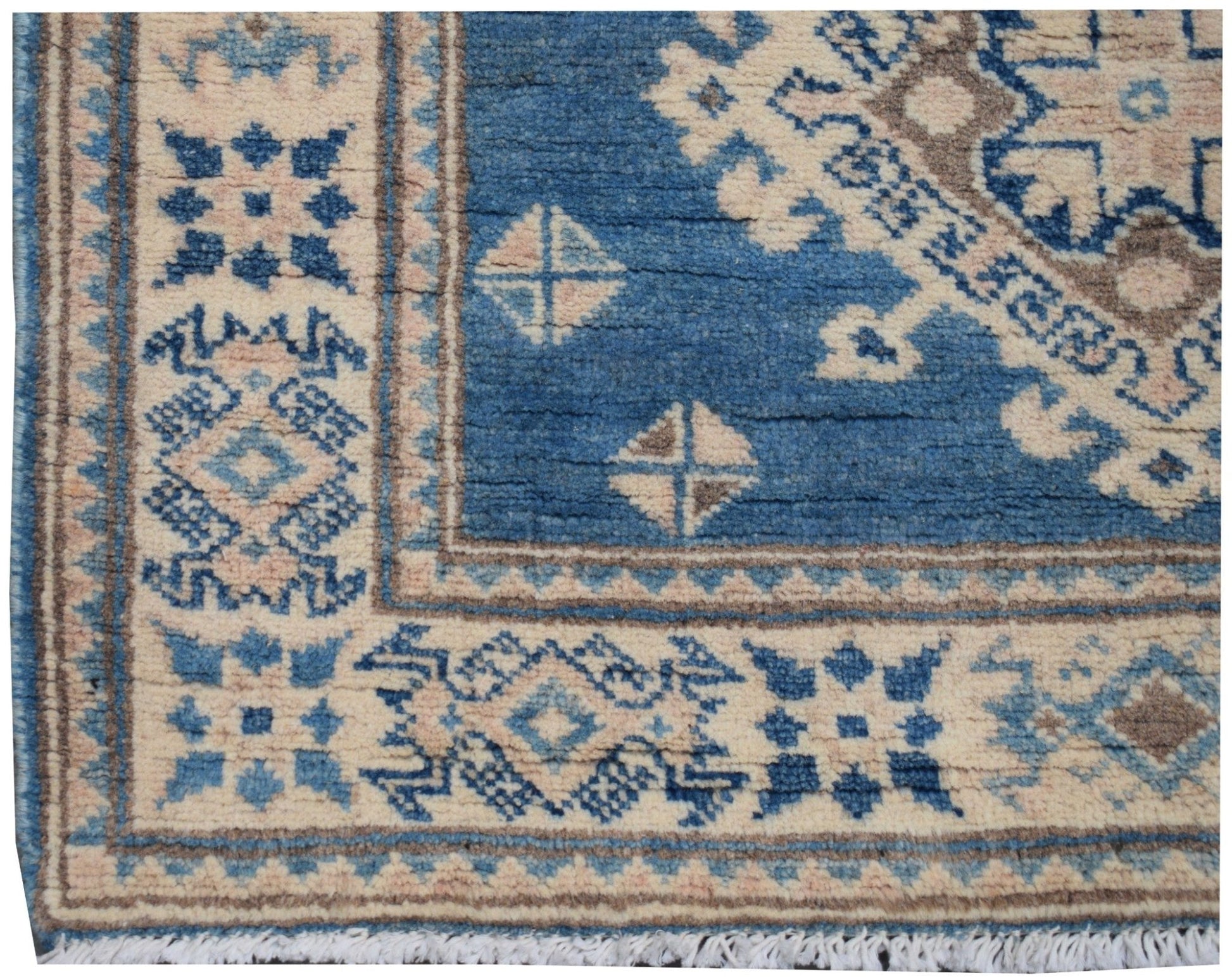 A handmade Afghan Kazakh runner featuring a geometric pattern in shades of blue, beige, and grey.