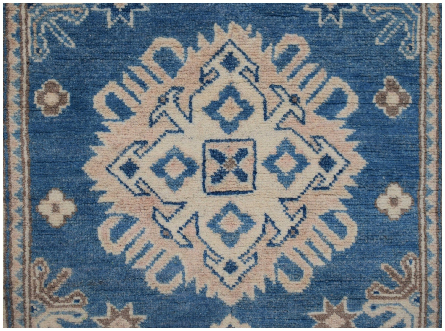 Handmade Afghan Kazakh runner featuring a central geometric medallion in beige and blue wool.