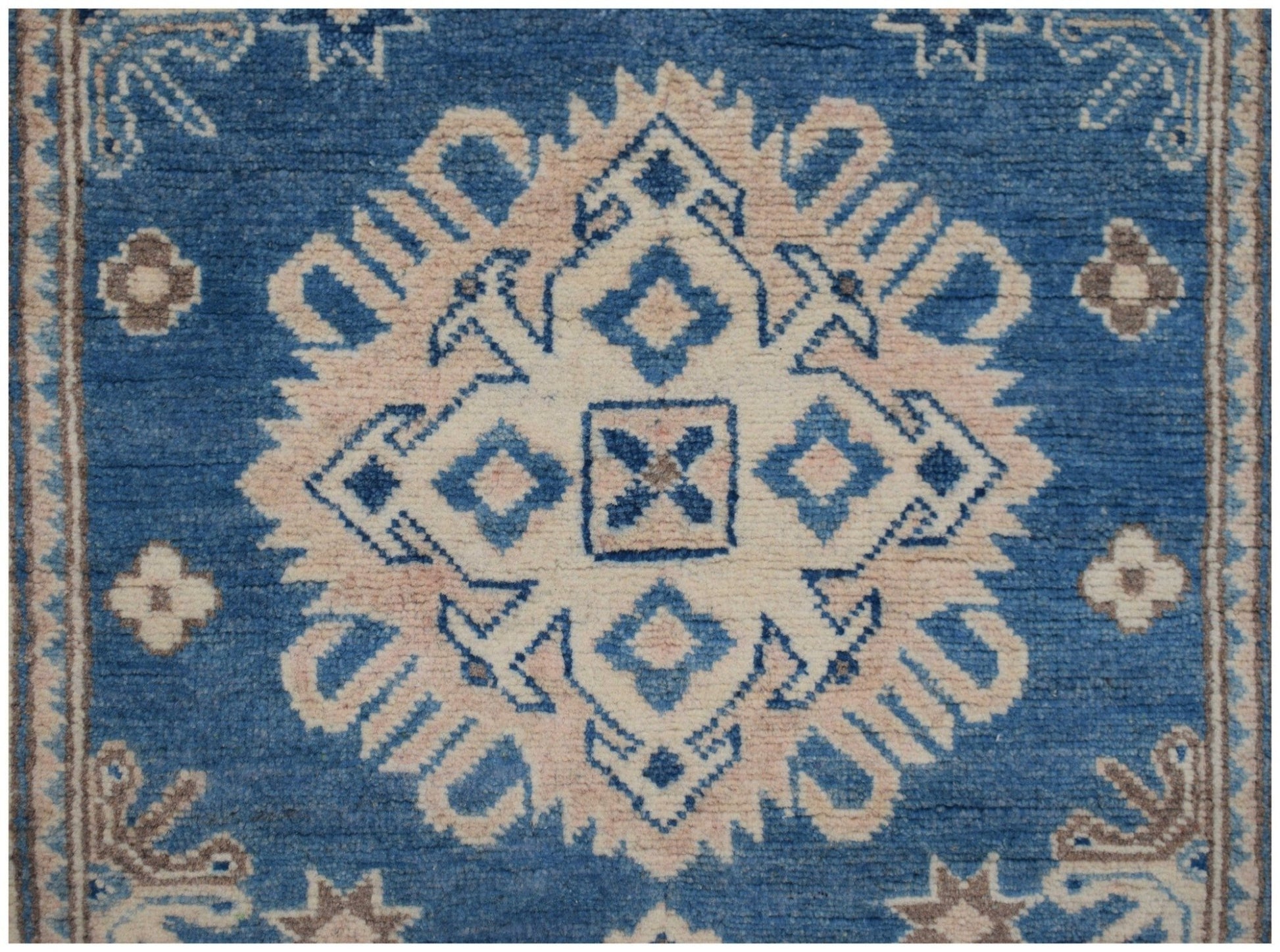 Handmade Afghan Kazakh runner featuring a central geometric medallion in beige and blue wool.