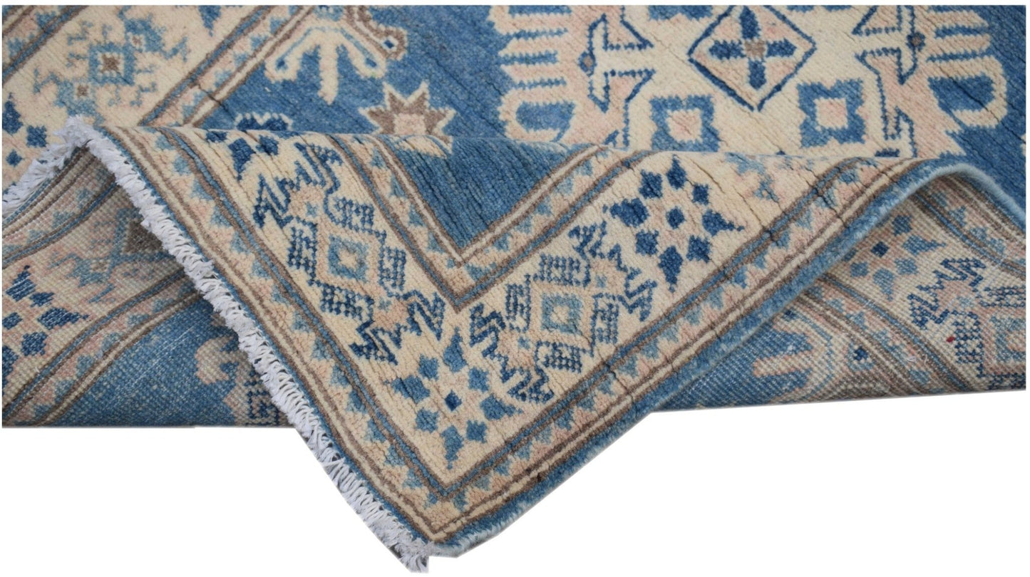 A handmade Afghan Kazakh runner featuring a geometric pattern in shades of blue and beige.