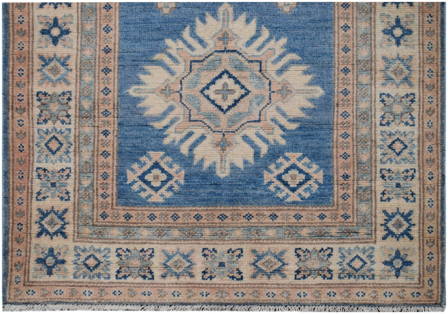 Handmade Afghan Kazakh runner rug featuring a blue field with a central beige geometric medallion.