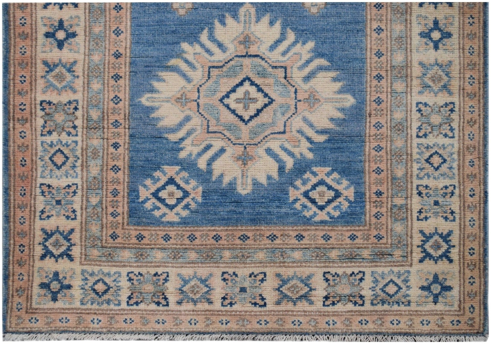 Handmade Afghan Kazakh runner rug featuring a blue field with a central beige geometric medallion.
