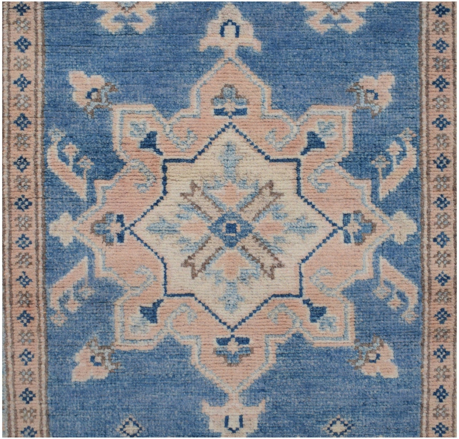 Handmade Afghan Kazakh runner featuring a central geometric medallion in blue, beige, and grey.