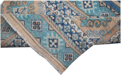 A handmade Afghan Kazakh runner rug featuring geometric patterns in shades of blue and beige.