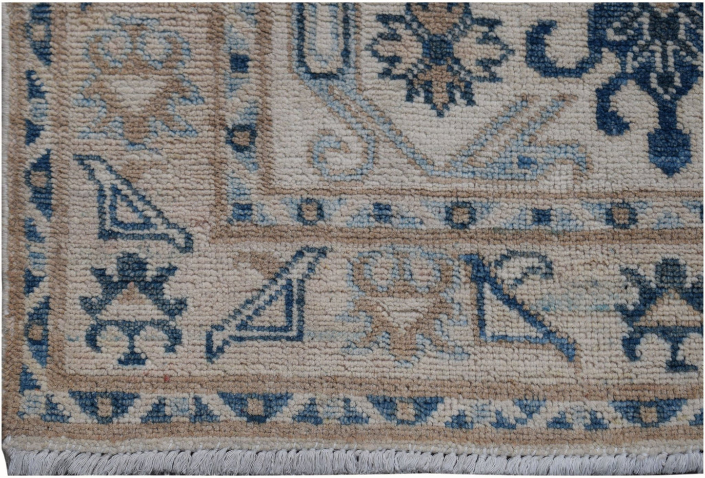 A handmade Afghan Kazakh runner featuring traditional blue and beige geometric patterns.