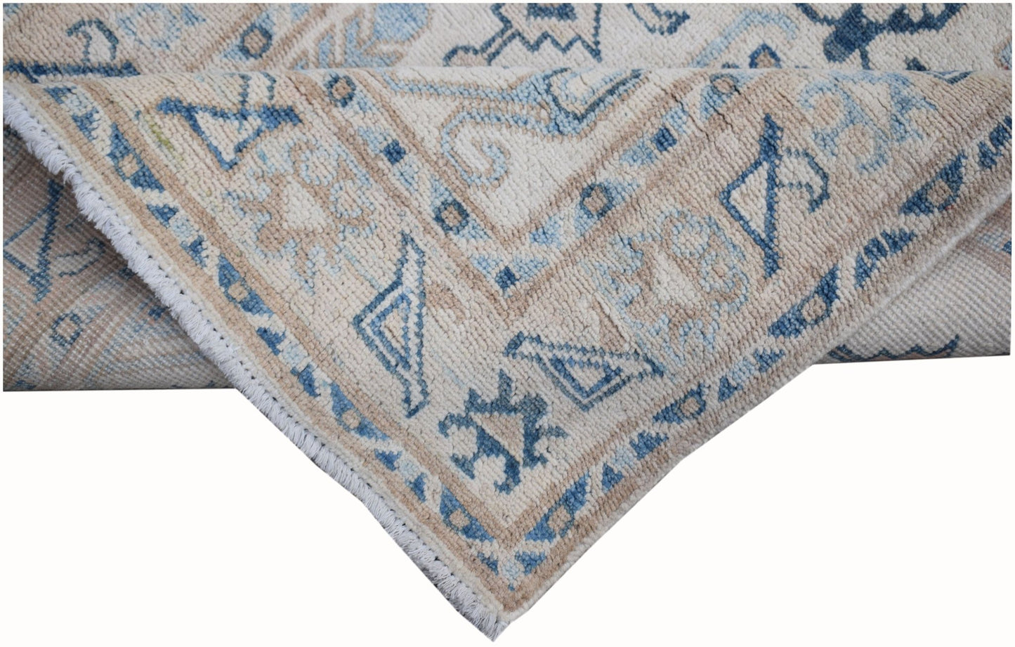 A handmade Afghan Kazakh runner featuring traditional blue and beige geometric patterns.