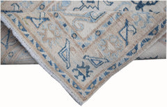 A handmade Afghan Kazakh runner featuring traditional blue and beige geometric patterns.