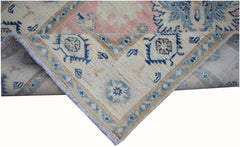A handmade Afghan Kazakh runner featuring a beige, blue, and pink geometric floral pattern.