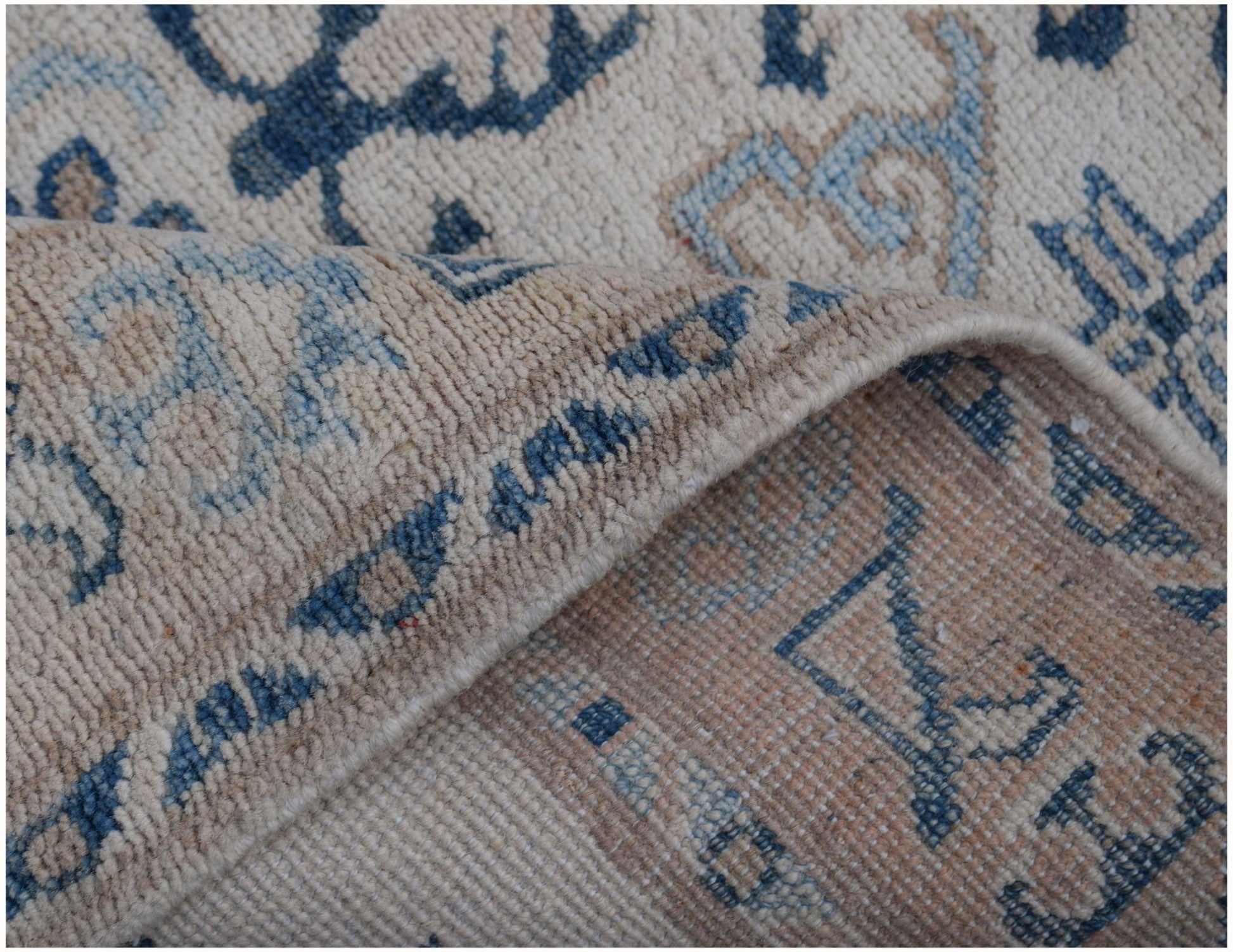 A handmade Afghan Kazakh runner featuring traditional blue and beige geometric patterns.
