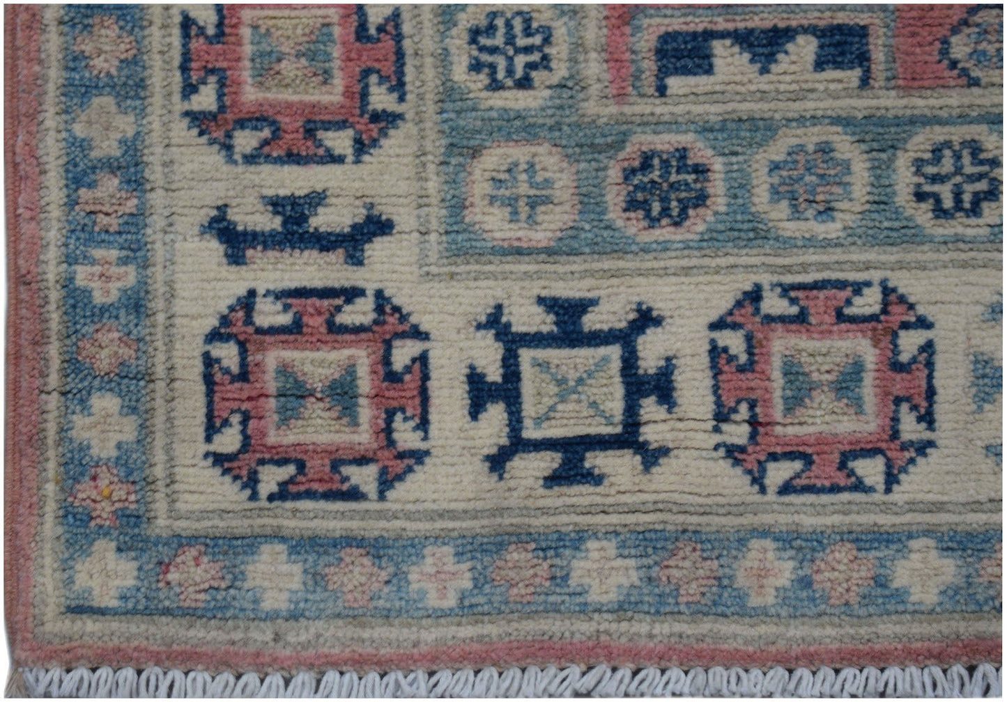 An Afghan Kazakh runner featuring traditional geometric motifs in blue, pink, and cream wool.