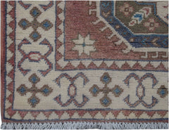 Handmade Afghan Kazakh runner featuring traditional geometric motifs in pink, blue, and cream.