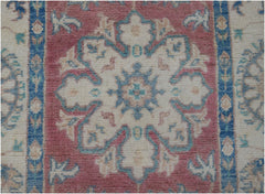 Handmade Afghan Kazakh runner featuring a central floral medallion in pink, blue, and cream wool.