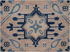Handmade Afghan Kazakh runner featuring a central blue geometric medallion on a beige wool field.