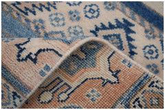 A handmade Afghan Kazakh runner rug featuring a beige and blue geometric pattern.