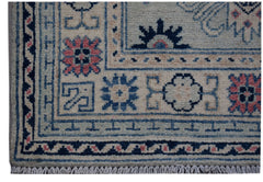 A handmade Afghan Kazakh runner featuring traditional geometric motifs in blue, pink, and cream.