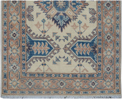 Handmade Afghan Kazakh runner featuring traditional geometric motifs in blue and tan on cream.