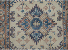 An Afghan Kazakh runner featuring a central geometric medallion in blue and tan on a cream field.