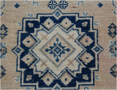 A handmade Afghan Kazakh runner featuring a geometric blue and cream medallion pattern.