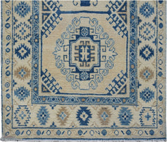 Handmade Afghan Kazakh runner rug featuring traditional blue and beige geometric patterns.