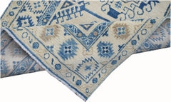 A handmade Afghan Kazakh runner featuring traditional blue and beige geometric patterns.
