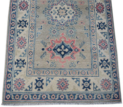 Handmade Afghan Kazakh runner rug featuring traditional geometric motifs in blue, pink, and beige.