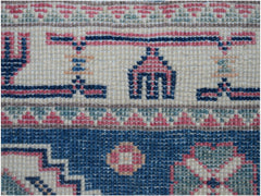 A close-up of an Afghan Kazakh runner featuring traditional geometric motifs in blue, pink, and tan.