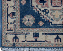A handmade Afghan Kazakh runner featuring traditional geometric motifs in blue, pink, and cream.