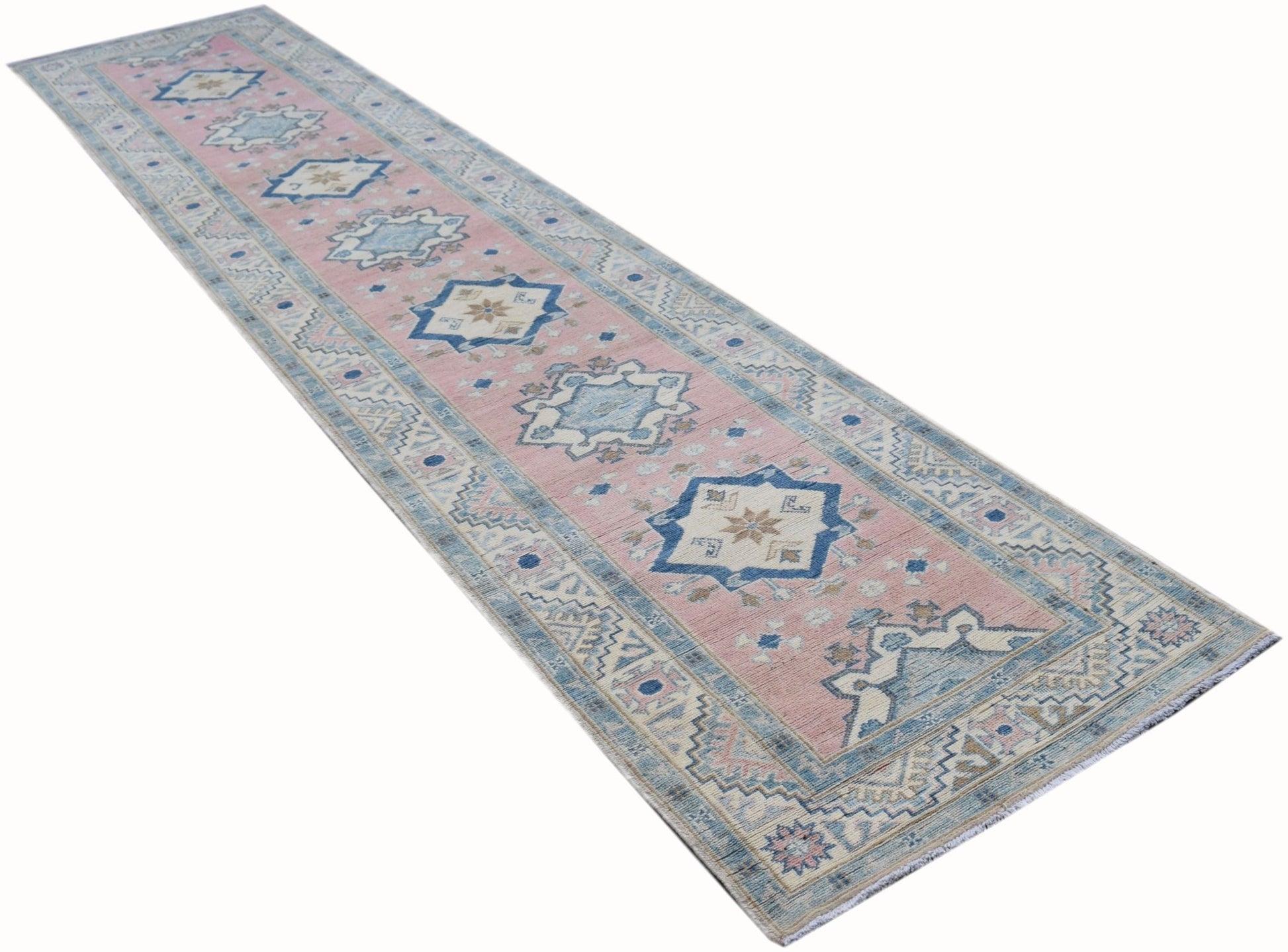 A handmade Afghan Kazakh runner rug featuring geometric patterns in soft pink and blue tones.