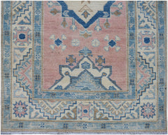 Handmade Afghan Kazakh runner featuring traditional geometric patterns in pink, blue, and cream.