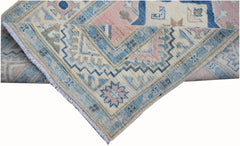 A handmade Afghan Kazakh runner featuring traditional geometric patterns in blue, pink, and cream.