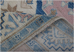 A handmade Afghan Kazakh runner featuring a traditional geometric pattern in blue, pink, and beige.