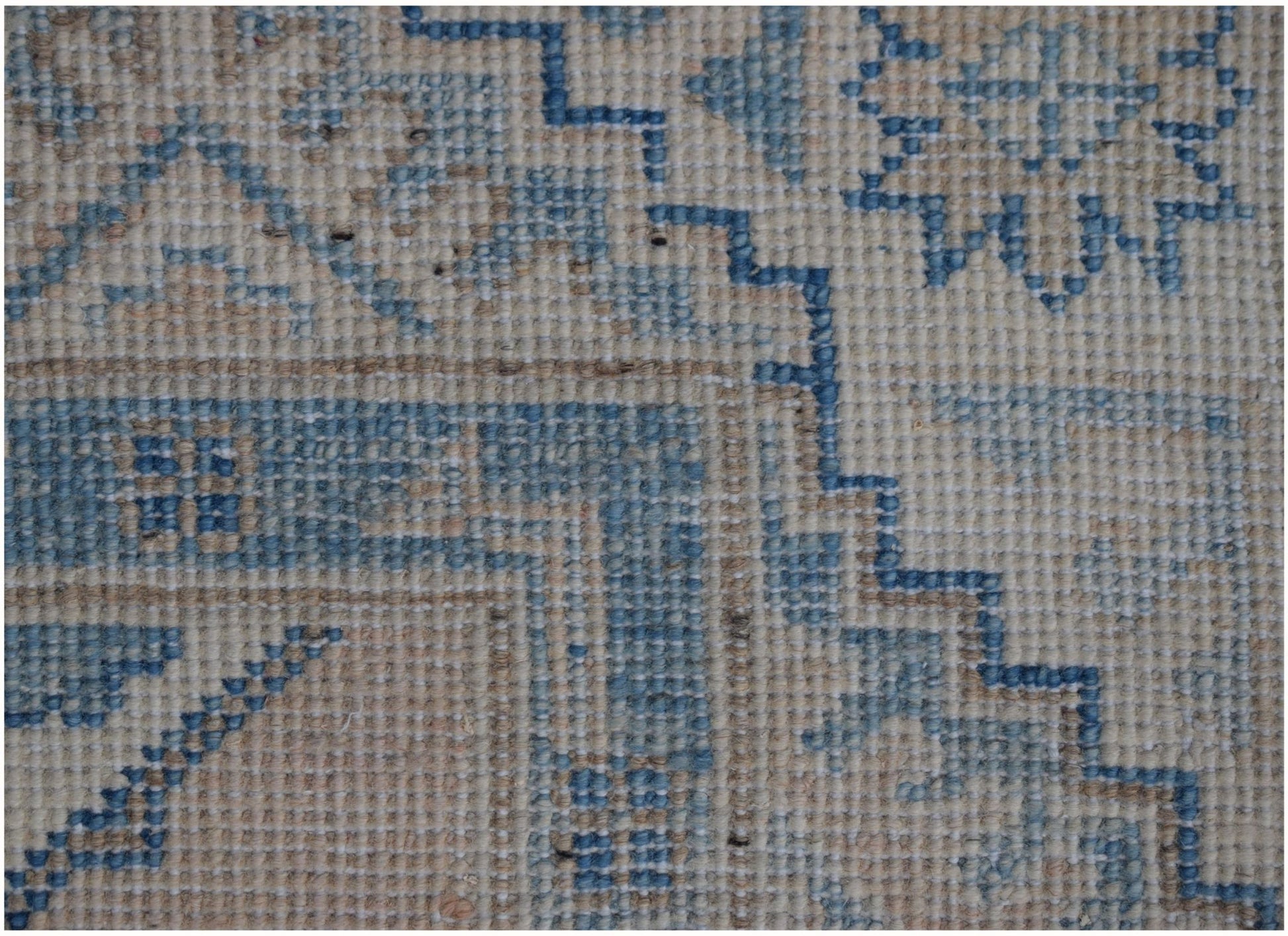 A handmade Afghan Kazakh runner featuring a traditional geometric pattern in blue and beige wool.