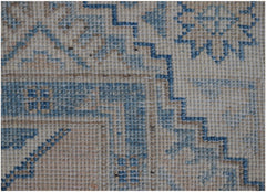 A handmade Afghan Kazakh runner featuring a traditional geometric pattern in blue and beige wool.
