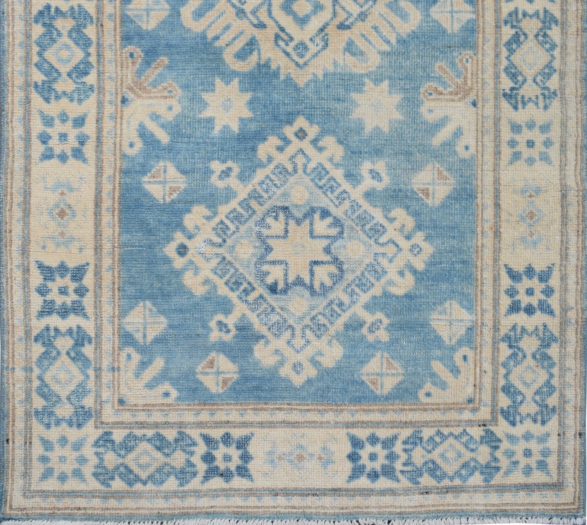 Handmade Afghan Kazakh runner rug featuring a geometric diamond pattern in blue and beige.