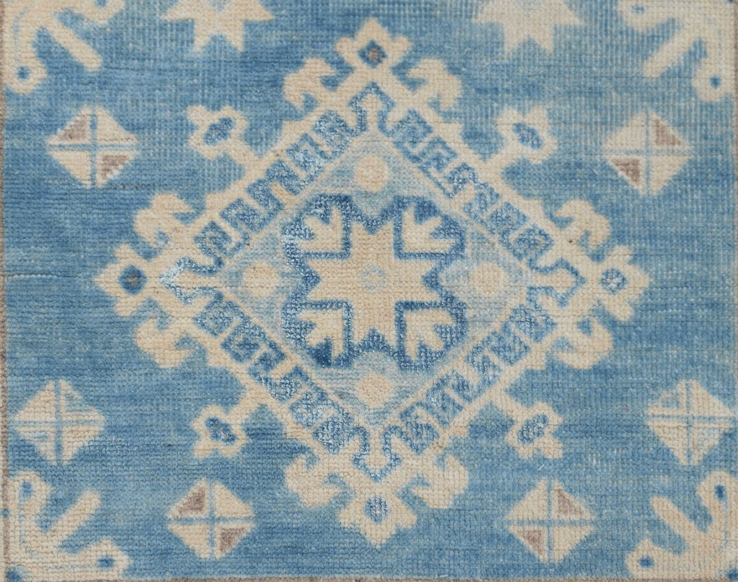 Handmade Afghan Kazakh runner featuring a geometric diamond pattern in shades of blue and beige.