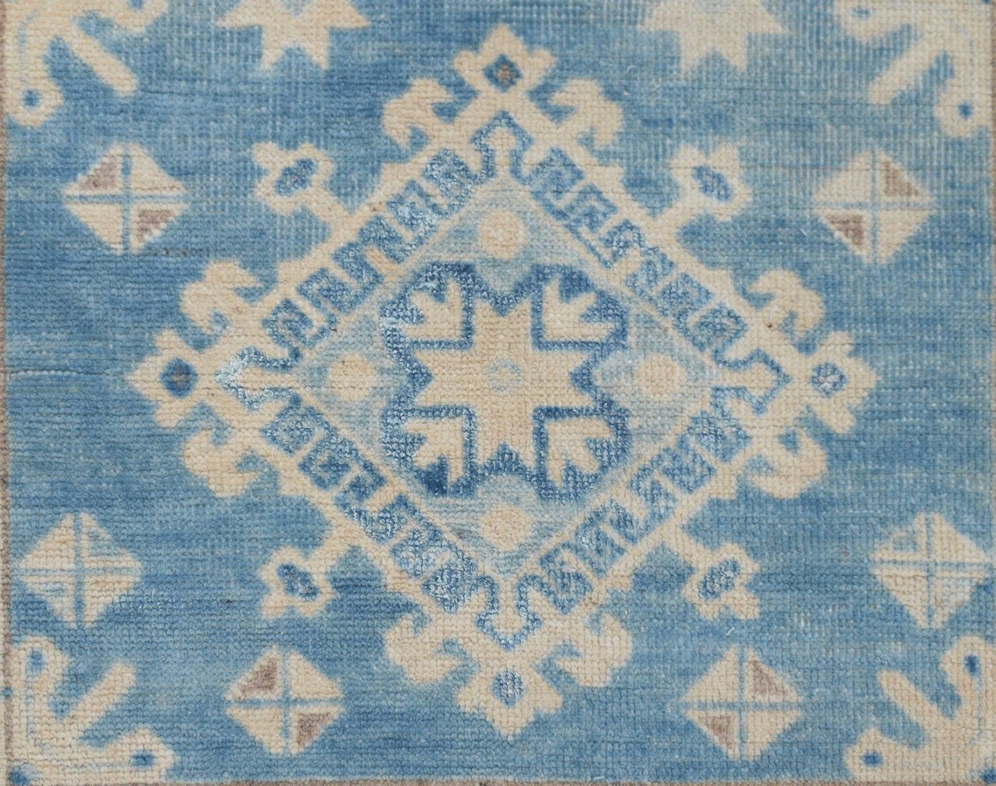 Handmade Afghan Kazakh runner featuring a geometric diamond pattern in shades of blue and beige.
