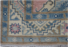 A handmade Afghan Kazakh runner featuring a geometric pattern in shades of blue, pink, and beige.