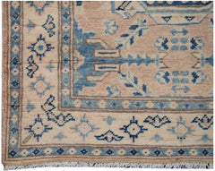 Handmade Afghan Kazakh runner rug featuring a geometric pattern in shades of beige and blue.