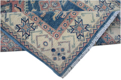 A handmade Afghan Kazakh runner featuring traditional geometric motifs in blue, pink, and cream.
